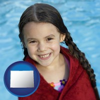 colorado map icon and a little girl wrapped in a dark red towel, in front of a swimming pool