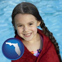 florida map icon and a little girl wrapped in a dark red towel, in front of a swimming pool