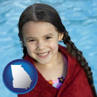 georgia map icon and a little girl wrapped in a dark red towel, in front of a swimming pool