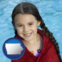 iowa map icon and a little girl wrapped in a dark red towel, in front of a swimming pool