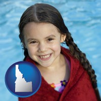 idaho map icon and a little girl wrapped in a dark red towel, in front of a swimming pool