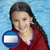 kansas map icon and a little girl wrapped in a dark red towel, in front of a swimming pool
