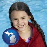 michigan map icon and a little girl wrapped in a dark red towel, in front of a swimming pool