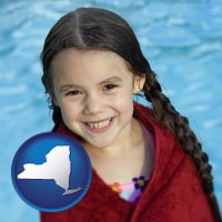 new-york map icon and a little girl wrapped in a dark red towel, in front of a swimming pool