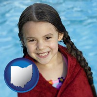 ohio map icon and a little girl wrapped in a dark red towel, in front of a swimming pool