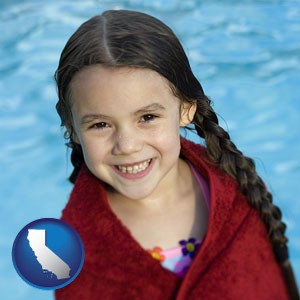 a little girl wrapped in a dark red towel, in front of a swimming pool - with California icon