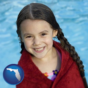 a little girl wrapped in a dark red towel, in front of a swimming pool - with Florida icon