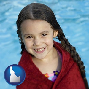 a little girl wrapped in a dark red towel, in front of a swimming pool - with Idaho icon