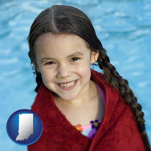 a little girl wrapped in a dark red towel, in front of a swimming pool - with Indiana icon