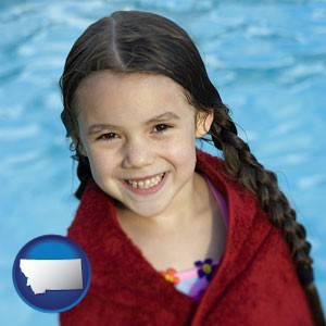 a little girl wrapped in a dark red towel, in front of a swimming pool - with Montana icon