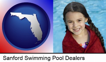 a little girl wrapped in a dark red towel, in front of a swimming pool in Sanford, FL