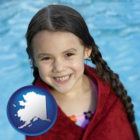 alaska a little girl wrapped in a dark red towel, in front of a swimming pool