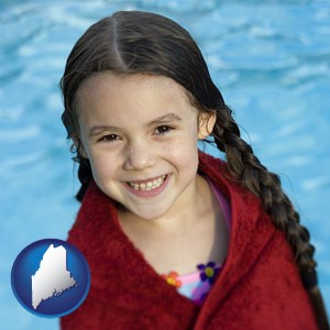 a little girl wrapped in a dark red towel, in front of a swimming pool - with Maine icon
